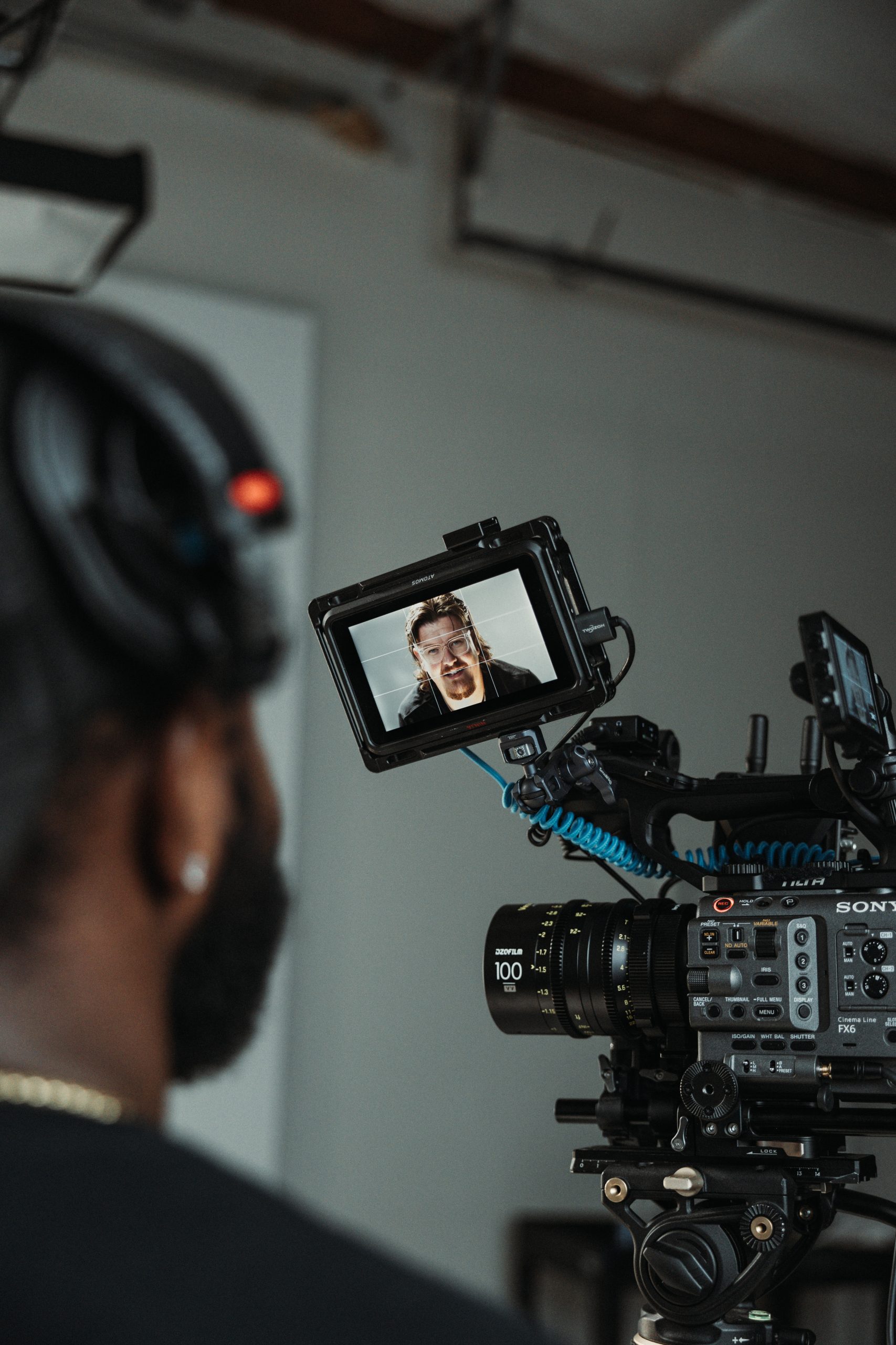 Over-the-shoulder view of a camera operator with talent on the monitor