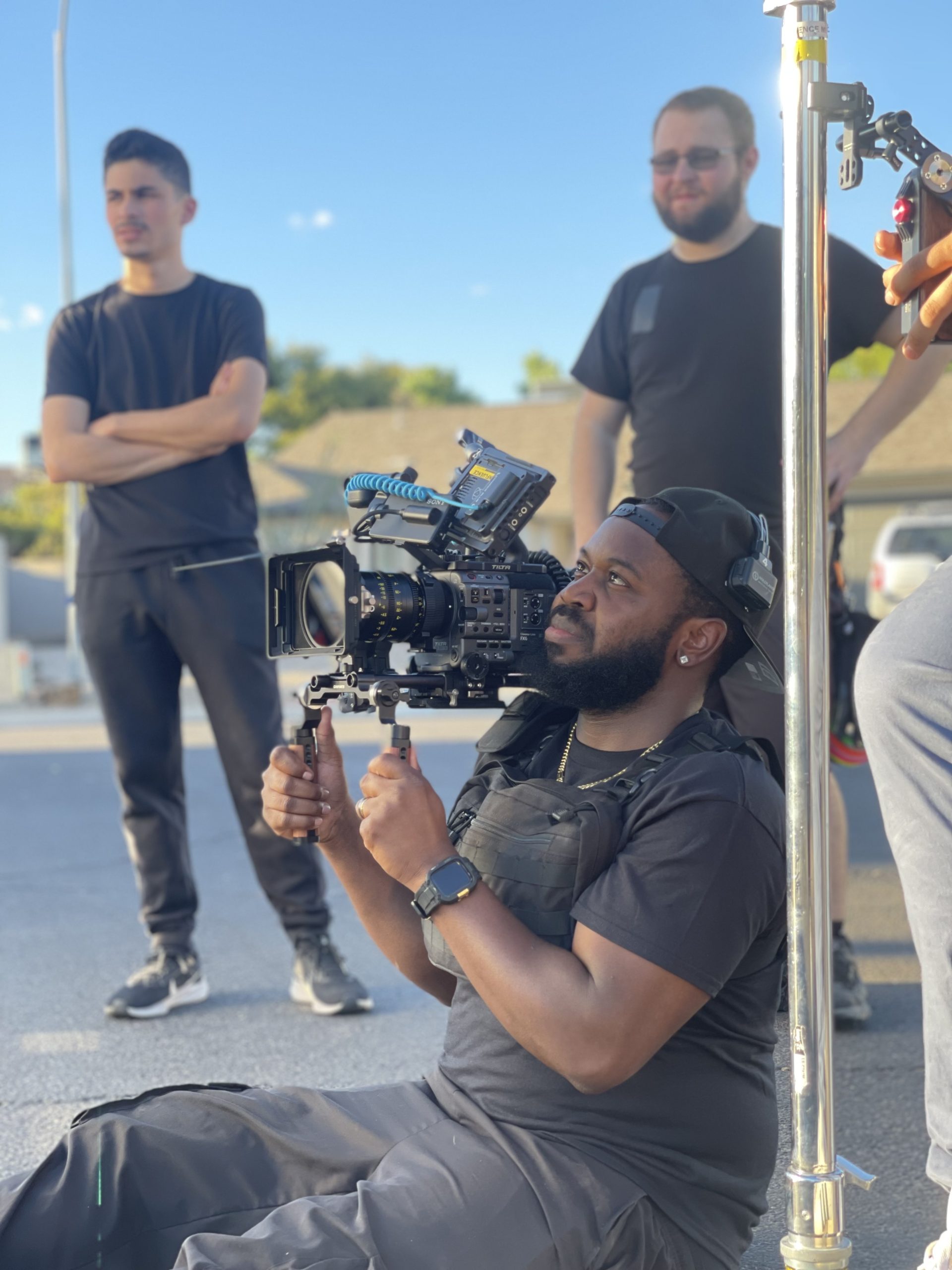 Crew filming outdoors with a gimbal rig at golden hour