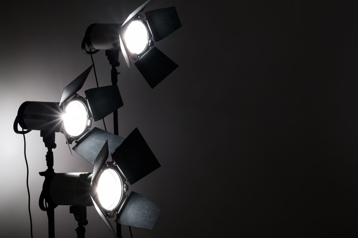 Barn-door studio lights glowing against a dark wall